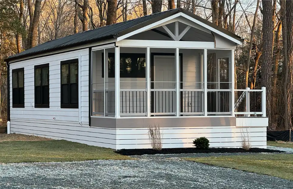 White park model cottage with a screened front porch used as an accessory dwelling unit