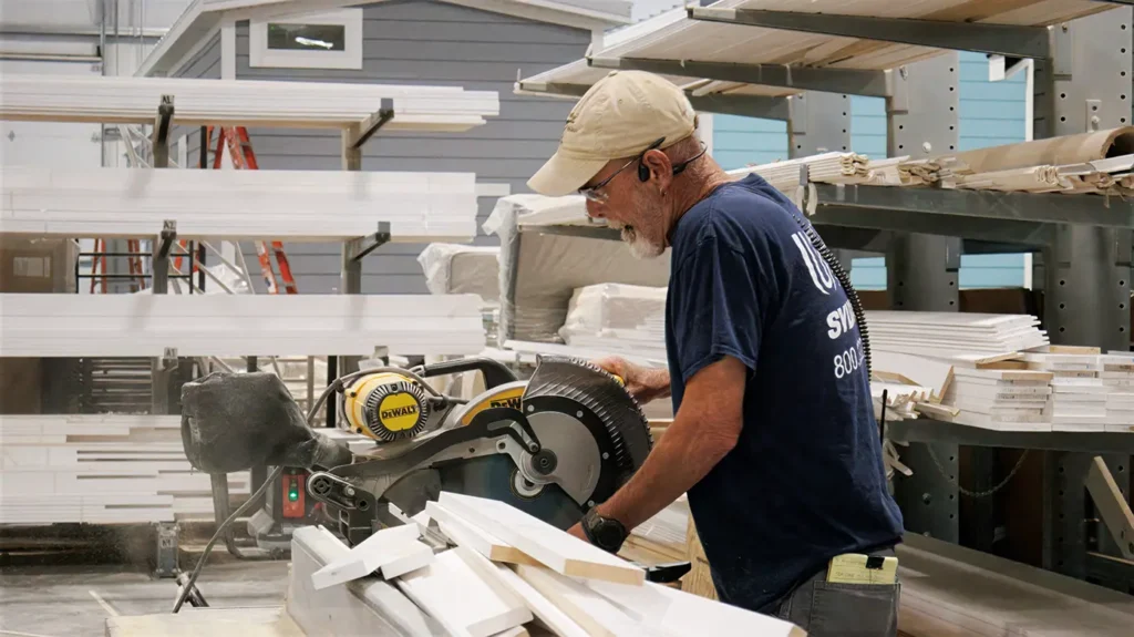 Craftsman cutting trim in the Great Outdoor Cottages factory