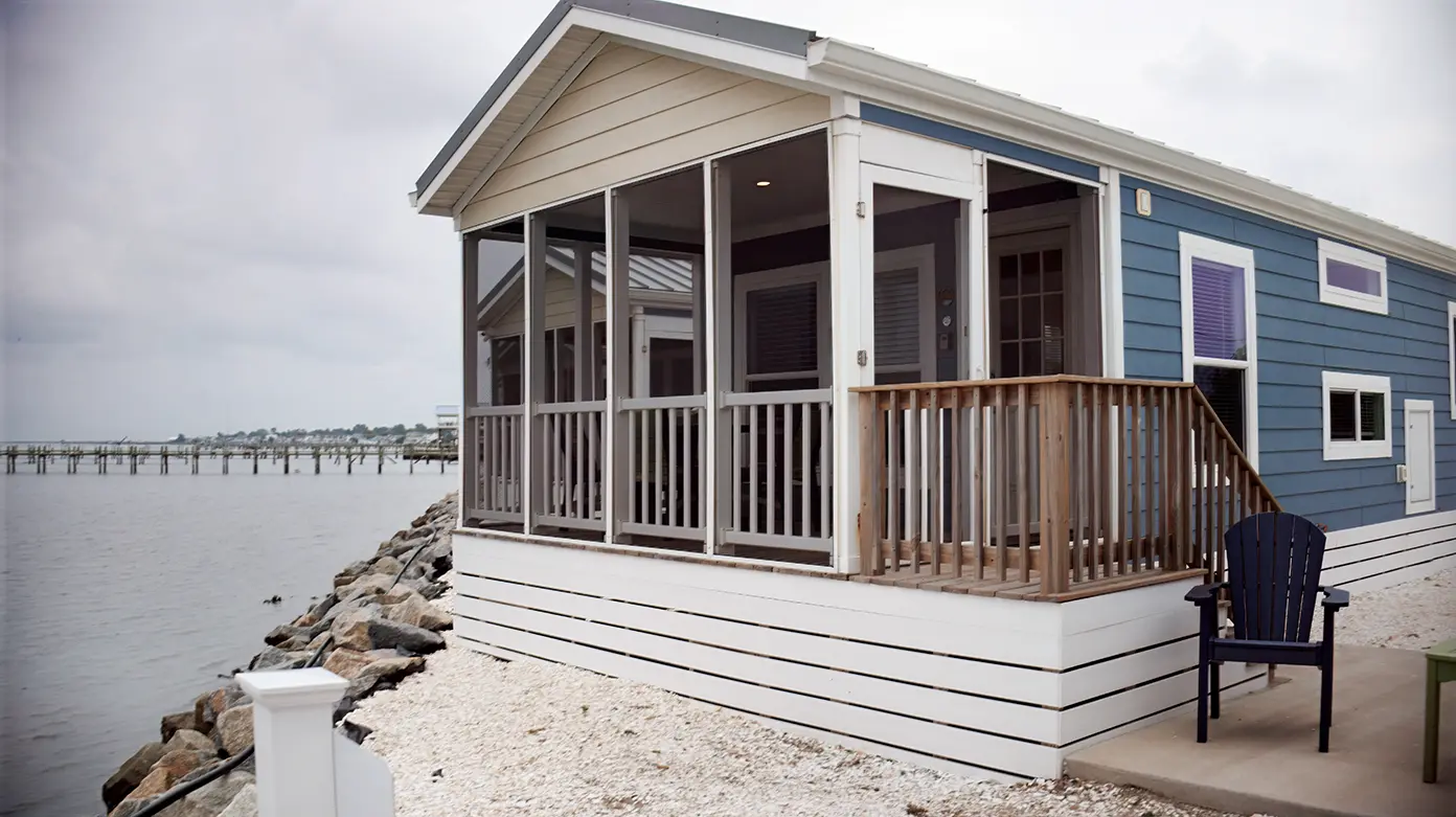 Blue park model cottage with screened porch on the waterfront