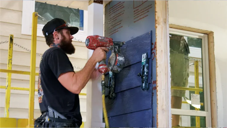 Carpenter installing siding on a cottage
