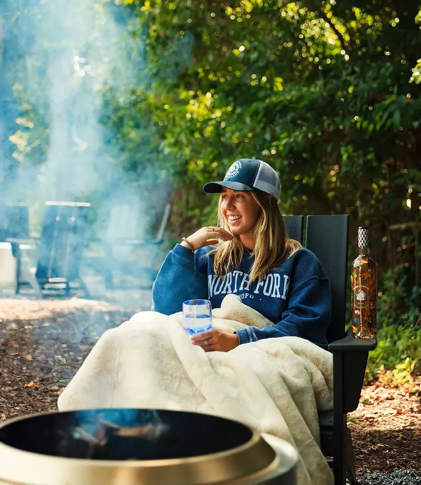 Woman relaxing by a fire pit at North Fork Resort