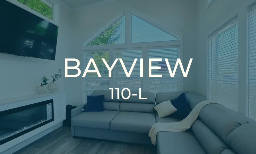 Bayview 110-L living room under the tall gable window wall, with electric fireplace and wall-mounted TV